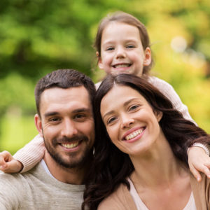 Mom and Dad smiling with their daughter on their shoulders