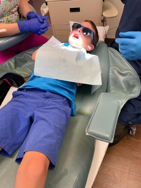 Boy in Dr. Heyn's dental chair wearing sunglasses.